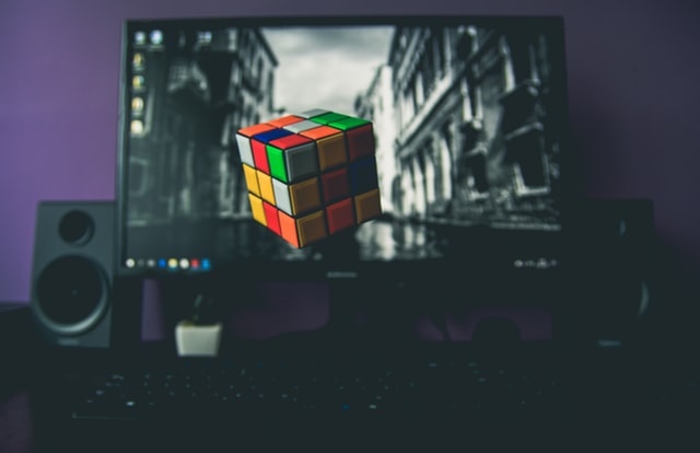 black computer speakers with a rubix cube