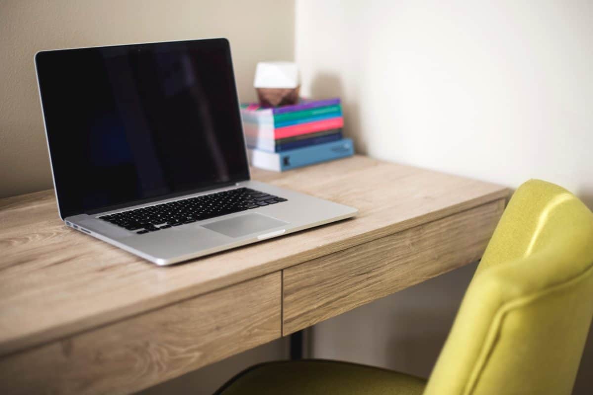 A computer placed on a wooden computer desk 